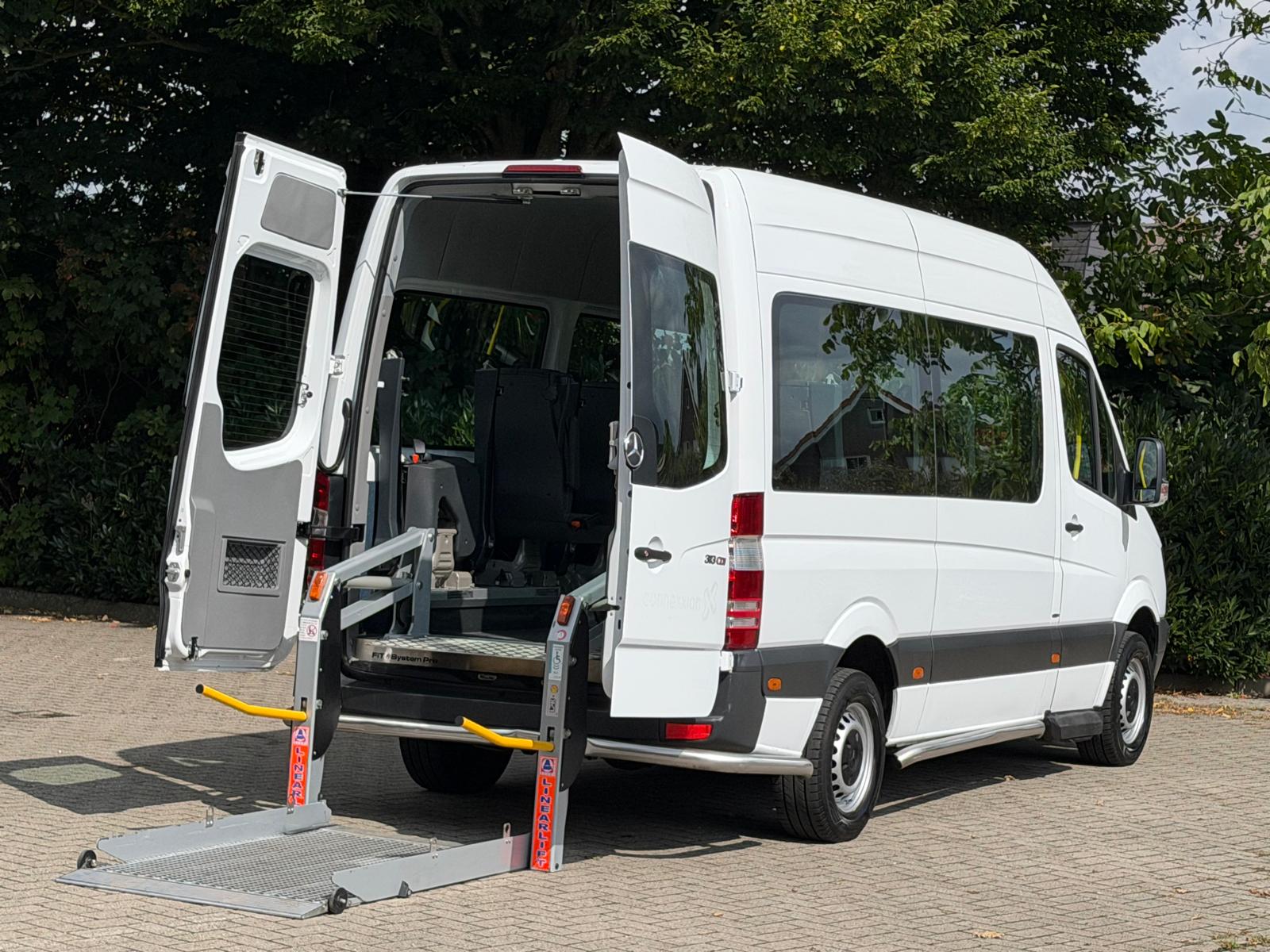 Fahrdienstfahrzeug mit geöffneten Hecktüren und abgesenktem Rollstuhllift